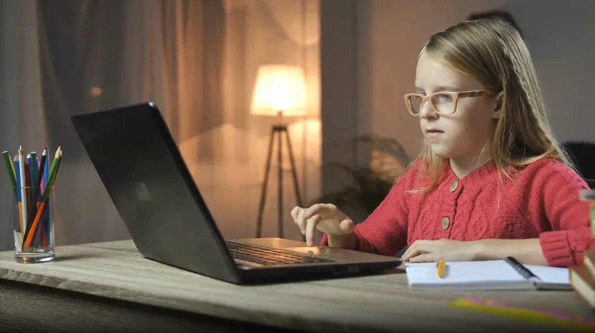 Cheerful child studying with laptop